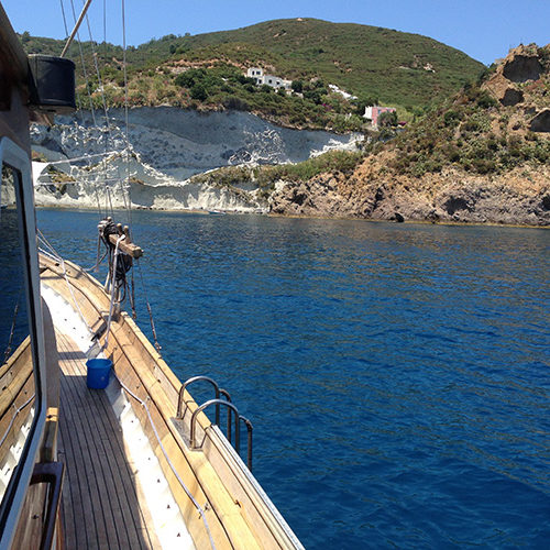 Il caicco lungo la costa di Ponza, tra falesie bianche e mare blu