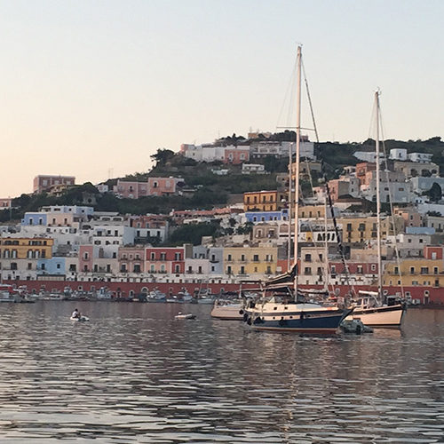 Barche a vela davanti alle case colorate del porto di Ponza