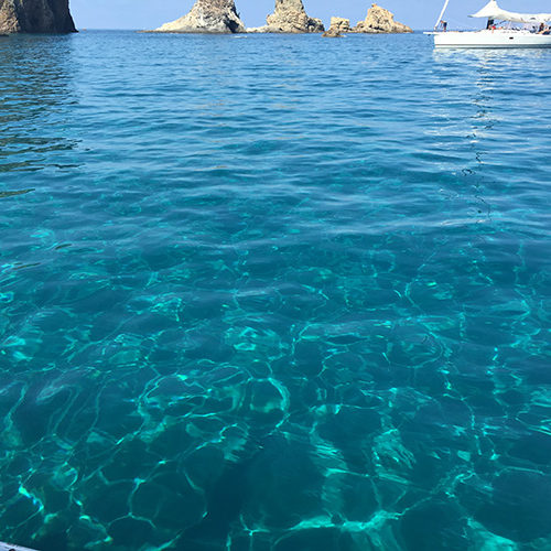 Mare turchese e trasparente con gli scogli di Ponza sullo sfondo