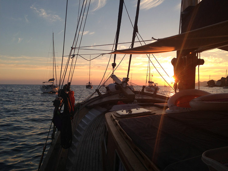 Alba vista dal ponte del caicco, con barche a vela all'orizzonte