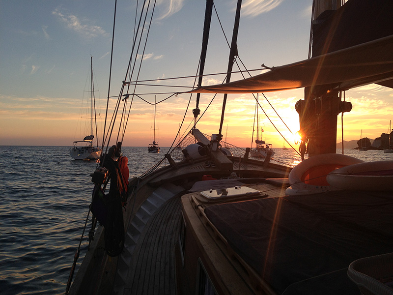 Alba vista dal ponte del caicco, con barche a vela all'orizzonte