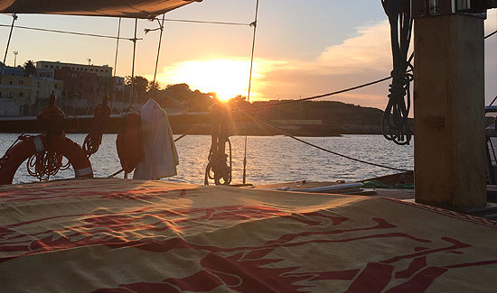 Prendisole del caicco al tramonto, con la costa sullo sfondo