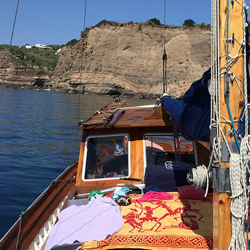 Il caicco alla fonda sotto le scogliere di tufo di Ventotene